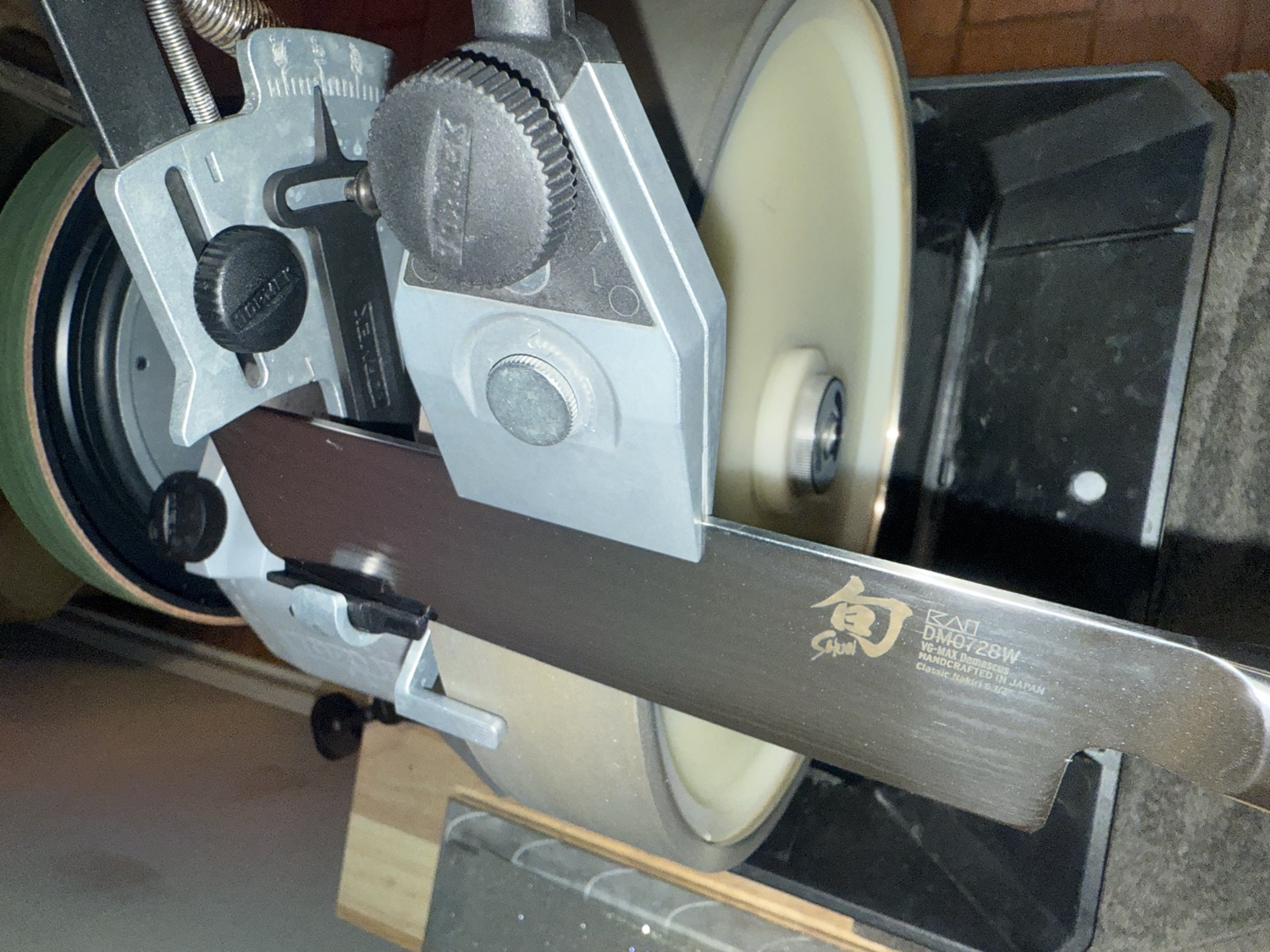 A Shun kitchen knife clamped in a jig on a Tormek sharpening machine